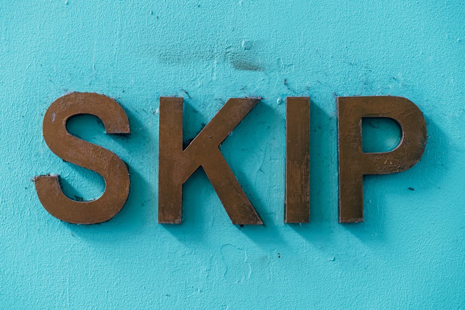 The image displays three-dimensional brown wooden letters spelling 'SKIP' mounted on a turquoise painted wall. The letters have a smooth matte finish, with visible wood grain and slight irregularities